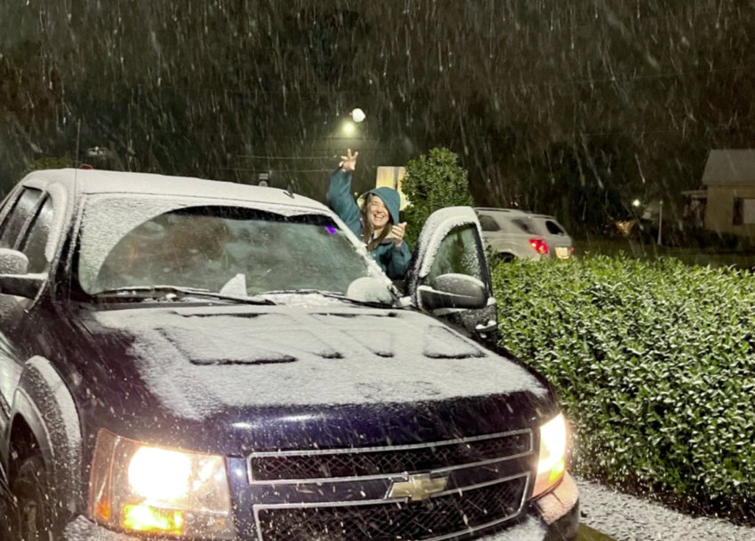 Barbara Yates Edwards throws a snowball at Linda Griffis Sunday night outside of The First Baptist Church in the first dusting of snow this year.
